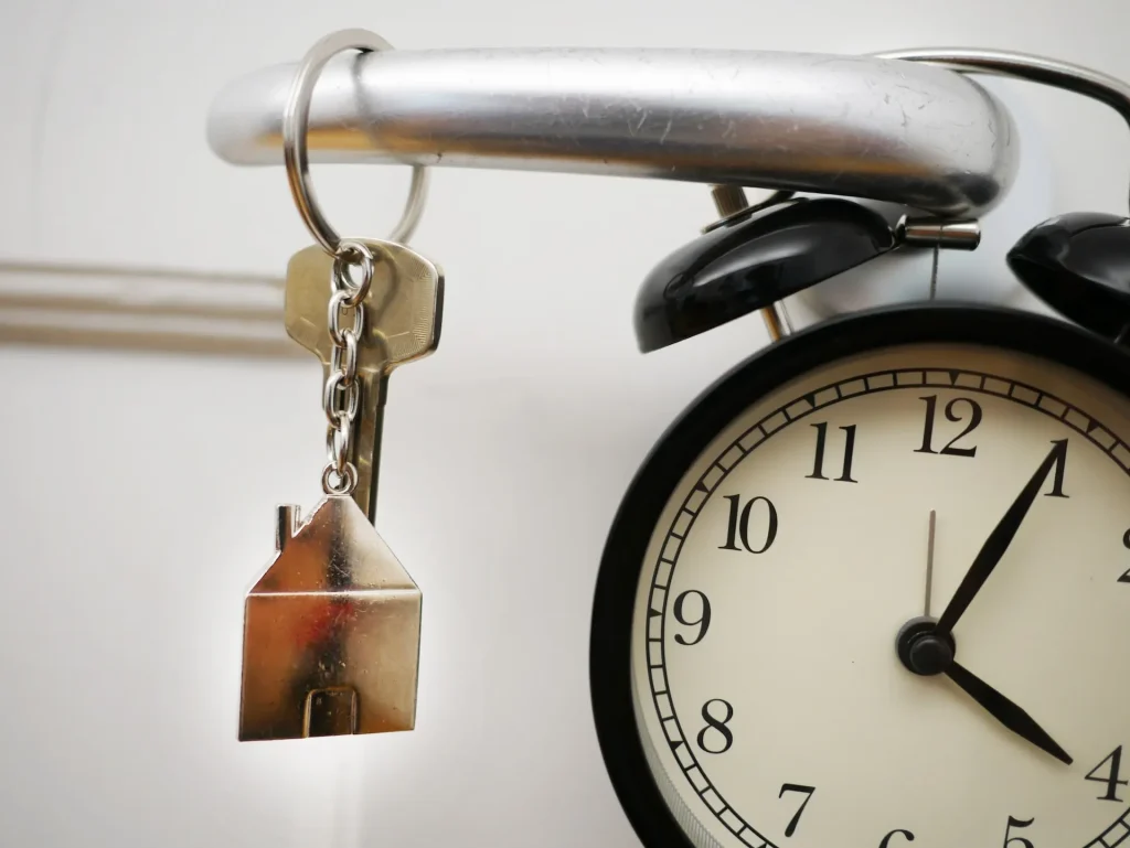 House key with home keychain and clock, symbolizing reliable emergency locksmith service availability.