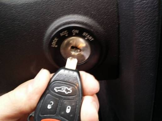 A person holding a car remote key, representing key extraction services for vehicles.