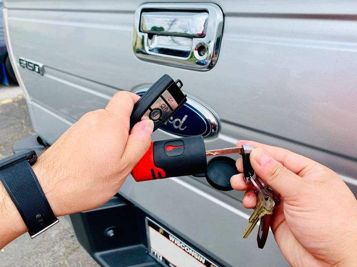 A person holding a replacement Lost U-Haul Truck Key with a remote, ready to unlock or start the vehicle after losing the original