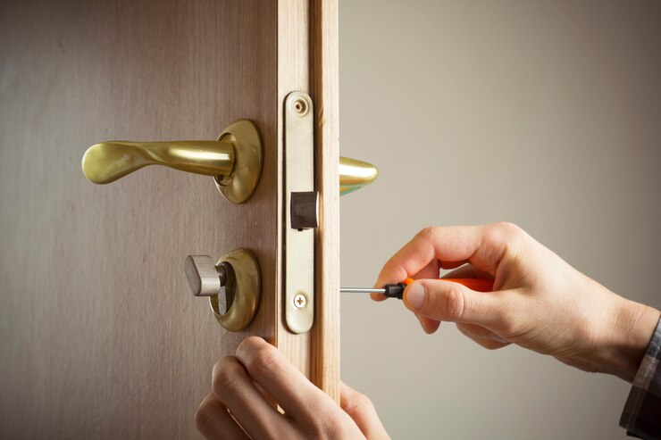 A person using a screwdriver to open a door, showcasing lock installation services in action